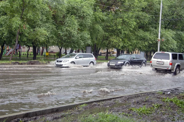 雨后汽车穿过路上的深水坑 — 图库照片