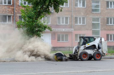 Özel bir makineyle yolun uygunsuz temizlenmesi. Çok tozlu ve kirli.