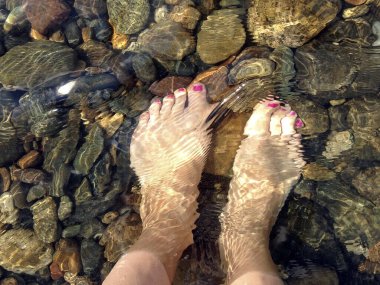 Temiz suda boyalı çivileri olan kadın ayakları. Fetiş