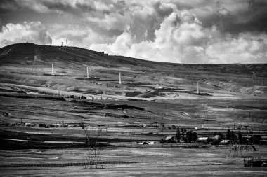 Çiftlik sahnede bulutlar ve inşaat ile siyah-beyaz tepe çöl