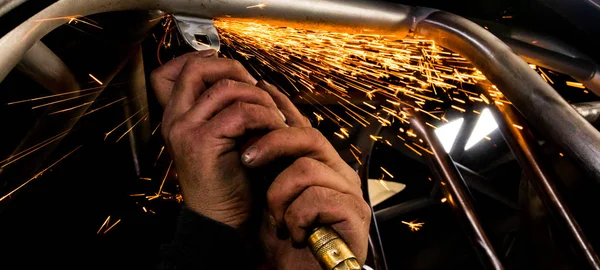 用热气动研磨盘喷出火花和矿渣的人磨钢管 — 图库照片