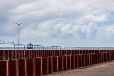 Ağır bulutlar ve bir sokak lambası ile Köprüsü yakınlarında bir iskele üzerinde görülen kargo gemisi