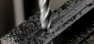 Bridgeport CNC end mill finishing a stack of steel plate with metal filings chips clipart