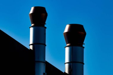 Endüstriyel dış hava havalandırma kanalı egzoz çıkışları mavi gökyüzü ile