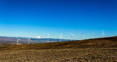 Bulutlar ve mavi gökyüzü yukarıdaki tepeler haddeleme üzerinde yeşil sürdürülebilir enerji fırıldak türbin elektrik jeneratörler