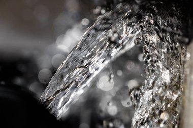 Su çeşme yakın çekim sıçramasına ve damlacıkları ile düşüyor