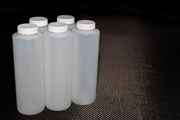 Білі Пластикові Контейнери Кришками Фоні Вуглецевого Волокна — стокове фото