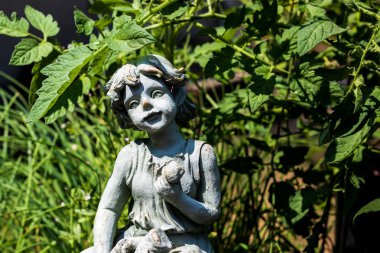 Taş bahçe heykel bir domates yama doğrudan güneş ışığı altında yer