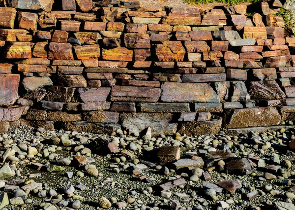 Gestapelte Eisenerzsteinmauer Entlang Einer Felsigen Strandpromenade — Stockfoto