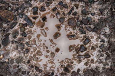 Küçük çakıl kayalar ile kirli çamur birikintisi