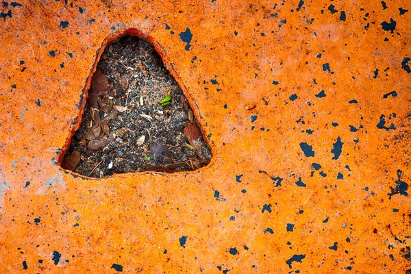 Orange steel plate on concrete with a triangle hole — Stock Photo, Image