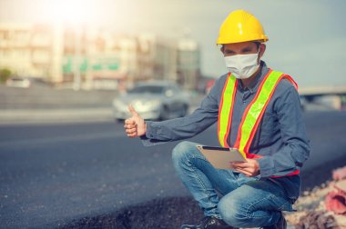 Tablet teknolojisi kullanan Asyalı mühendis inşaat alanında çalışıyor yol teftişi uzmanlık alanı tablet üzerinde çalışıyor