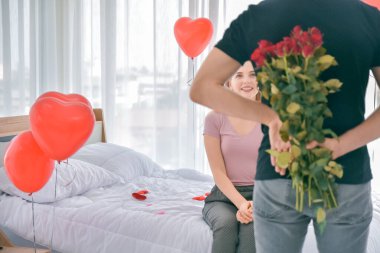 Sevgililer Günü sabahı yatak odasında bir çift sürpriz gül çiçeği