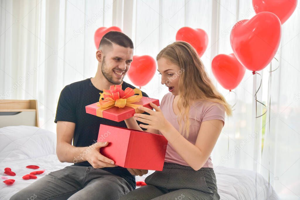 Love Couple giving gift box in bedroom happiness in love Valentine's day concept