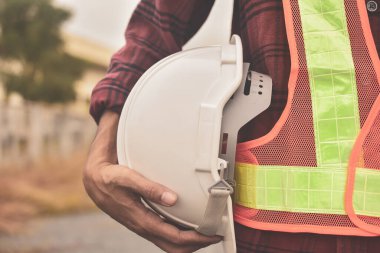 Miğfer tutan adam, sağlam kasklı güvenlik inşaat konsepti.