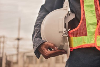 Miğfer tutan adam, sağlam kasklı güvenlik inşaat konsepti.