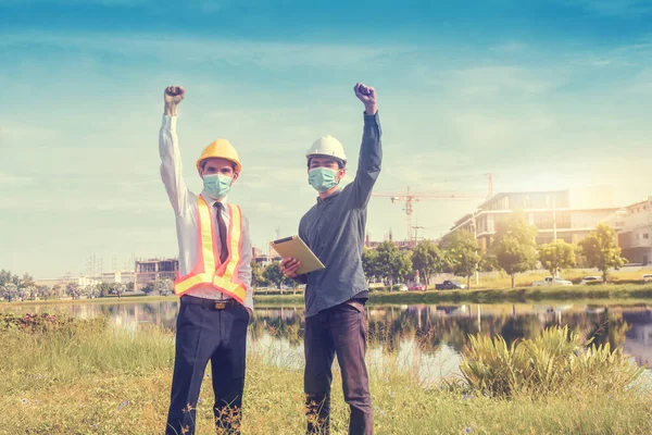 Team Engineer wearing face mask on site construction, Engineer teamwork success achievement project