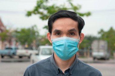 Asyalı adam Corona virüsü Covid 19 'u korumak için sağlık maskesi takıyor.