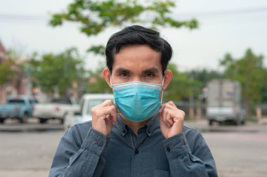 Asyalı adam Corona virüsü Covid 19 'u korumak için sağlık maskesi takıyor.