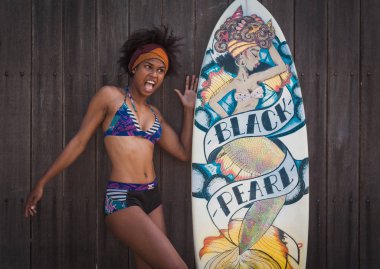 young gorgeous african-american woman posing with surfboard  clipart