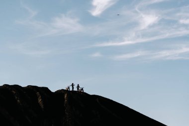 İki arkadaş sonraki kir enduro motosiklet üzerinde siyah lav mount Batur, Bali, Endonezya güneş doğarken ayakta