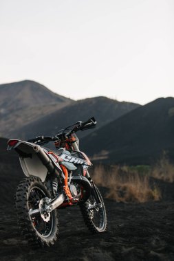 Dirt motocross enduro motosiklet üzerinde gündoğumu, siyah lav mount Batur, Bali, Endonezya üzerinde yarış için hazır