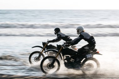 İki arkadaş özel retro yarış kafe racer siyah motosiklet sahilde günbatımı Tabanan, Bali, Endonezya, stil