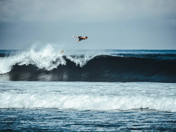 Erkek sörfçü büyük mavi okyanus dalgaları sürme