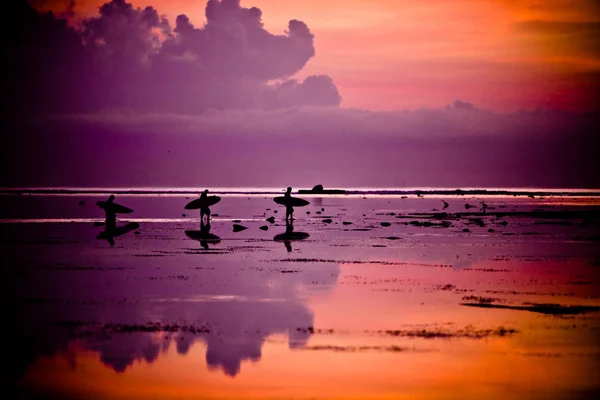 güzel gün batımı üzerinde Sahil tarafından yürüyüş sörfçü hareket çekimi