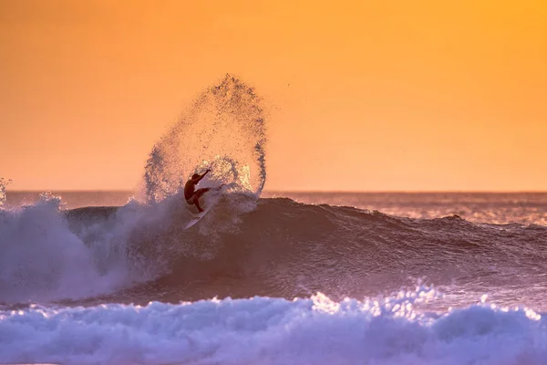 gün batımı üzerinde büyük okyanus dalgası sürme sörfçü hareket çekim