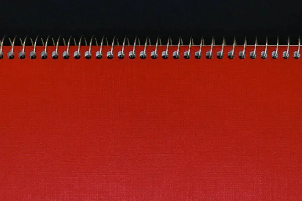 Background of red notebook cover with silver metal spirals with free copy space