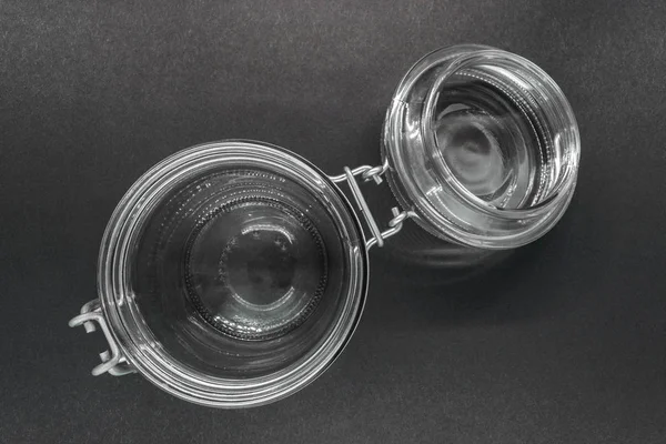 Siyah zemin yüzeyinde metal sahibi ile açık cam kavanoz