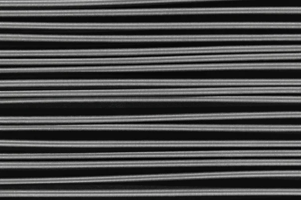 Metal springs placed horizontally on black background surface