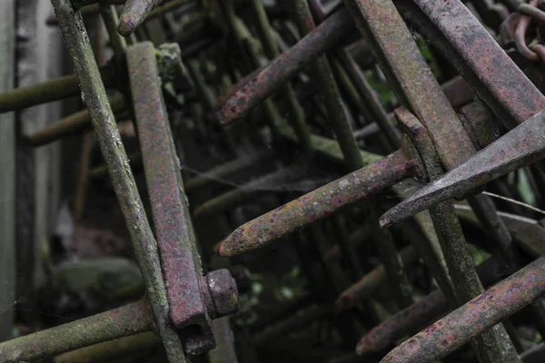 Çok eski ve paslı tırmıklar yerleri kırsal ahır duvarının yakınında