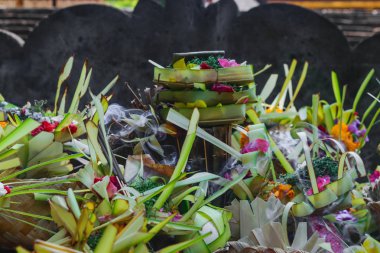 Canang denilen ve yaprakları ve çiçekleri yapılmış Bali Adası Hint Tanrıları için sunan