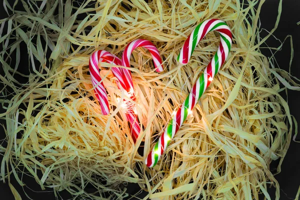 Bengalas Doces Natal Iluminado Por Guirlanda Colocado Sobre Palha Fundo — Fotografia de Stock