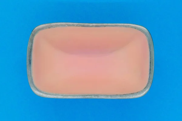 青の背景にシルバー エッジを持つ長方形のピンク空の皿のトップ ビュー — ストック写真