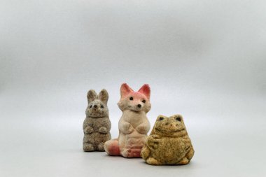 Gri arka plan yüzeyi kopya alanı ile çok eski tavşan, tilki ve kurbağa yumuşak oyuncaklar