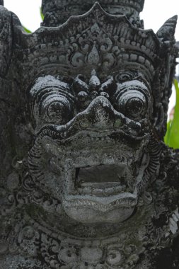 Bali, Endonezya. 8 Ekim 2018. Korkunç görünümlü geleneksel Bali Adası siyah taş heykel yosun ve likenler ile kaplı