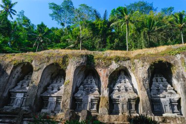 Gunung Kawi tapınak karmaşık taş kayalıklarla ormanlarda uçurumdaki ile oyulmuş ve mavi gökyüzü Bali, Endonezya temizleyin