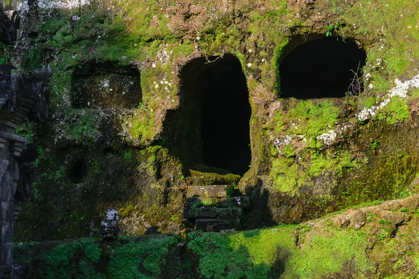 Carved in the stone ancient Gunung Kawi Temple with royal tombs illuminated by evening sun and leading path through the jungles in Bali, Indonesia