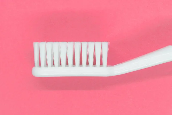 White toothbrush on pink background — Stock Photo, Image