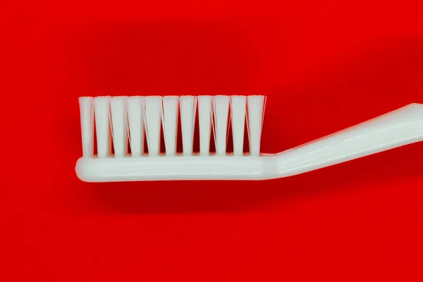 White toothbrush on red background — Stock Photo, Image
