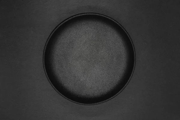Cast iron bowl on grey stone background