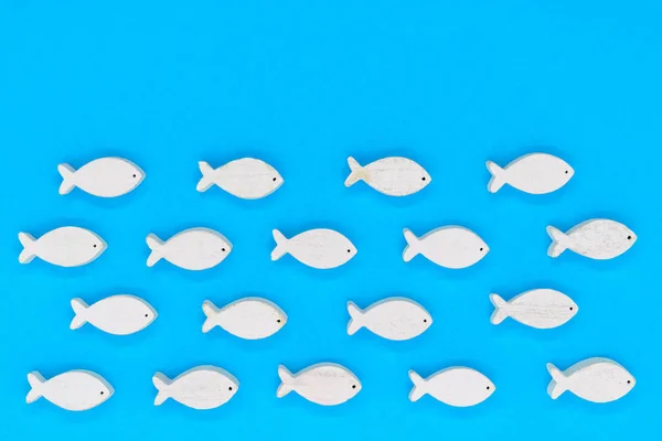 Peixes brancos de madeira no fundo azul — Fotografia de Stock