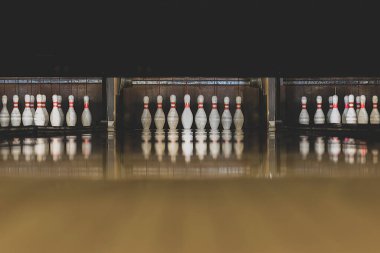 Boş zaman, eğlence ve aktivite konsepti. Eski ve koyu parke bowling pistinin kopyasıyla soyut arkaplan sonunda beyaz raptiyeler olan