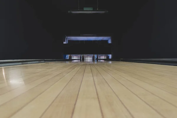 Boş zaman, eğlence ve aktivite konsepti. Eski ve koyu parke bowling pistinin kopyasıyla soyut arkaplan sonunda beyaz raptiyeler olan