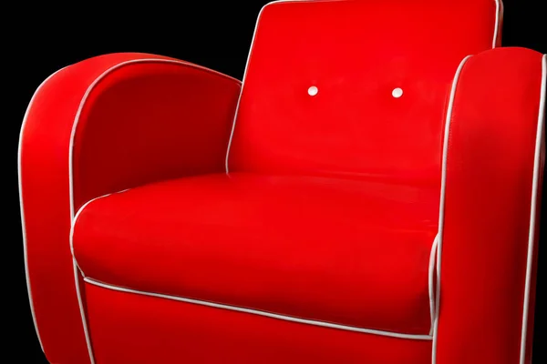 Luxury red armchair with white edgings isolated on black background