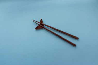 Mavi arka plan kopya alanı ile Japon ve Çinli yemek ahşap çubuk çifti. Seyahat ve mutfağı kavramı. Asya gıda kültür kavramı. Suşi yemek çubukları kümesini. 