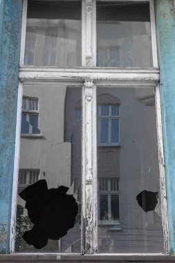 Terk edilmiş eski binada kırık pencere cam. Kirli cephe. İmha kavramı. Vandalizm kavramı. Grunge mimari dış. Yansıması ile kırık pencere.